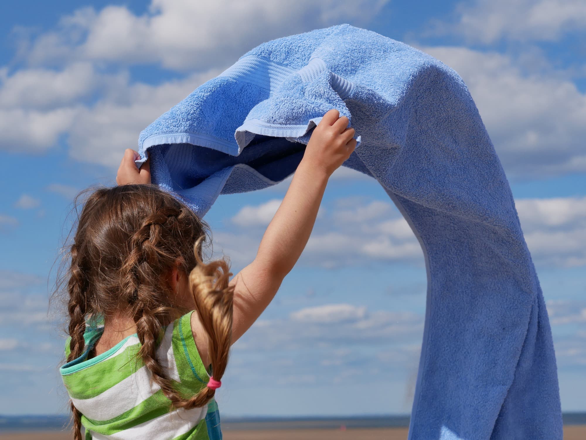 niña con su toalla doblandola y cuidandola